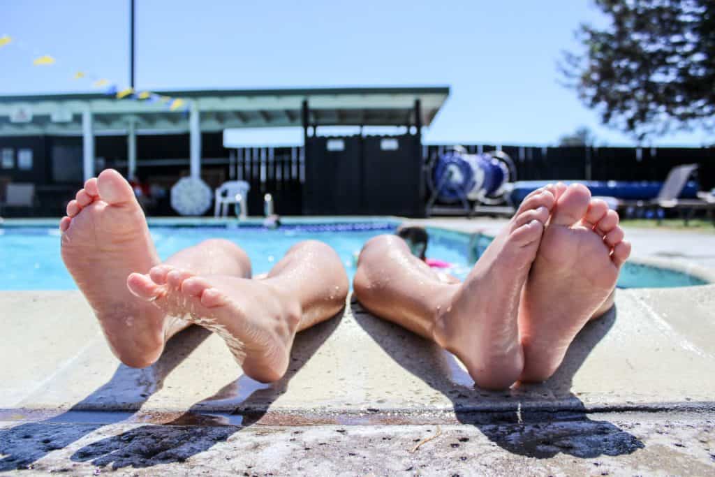 repeat vacations a photo of two kids in a swimming pool with their feet on the decking