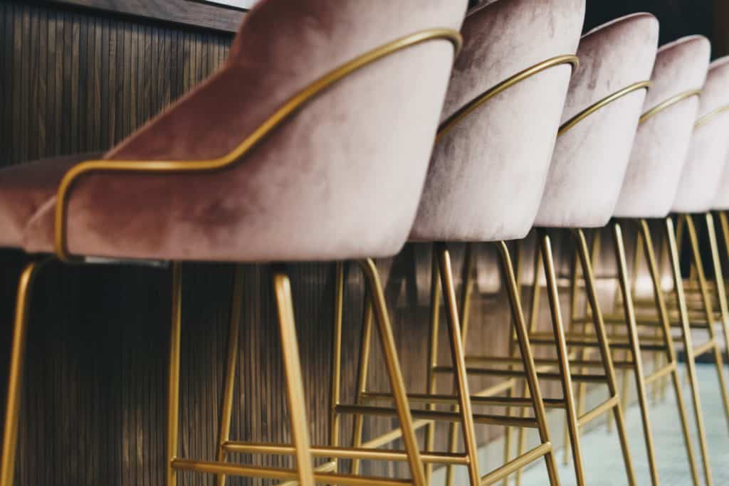 a photo of pink velvet bar stools with brass legs